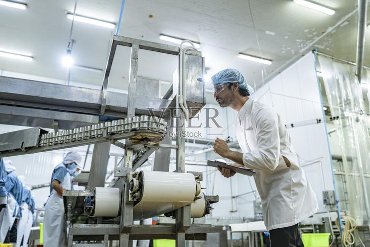 质量保证科学家检查员在高科技食品制造厂监控设备专注于效率食品安全